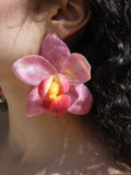 Boucle d’oreille orchidée rose et fuchsia avec cœur jaune doré portée par un modèle