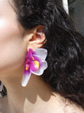 Boucle d’oreille orchidée violet intense et blanc nacré portée par un modèle