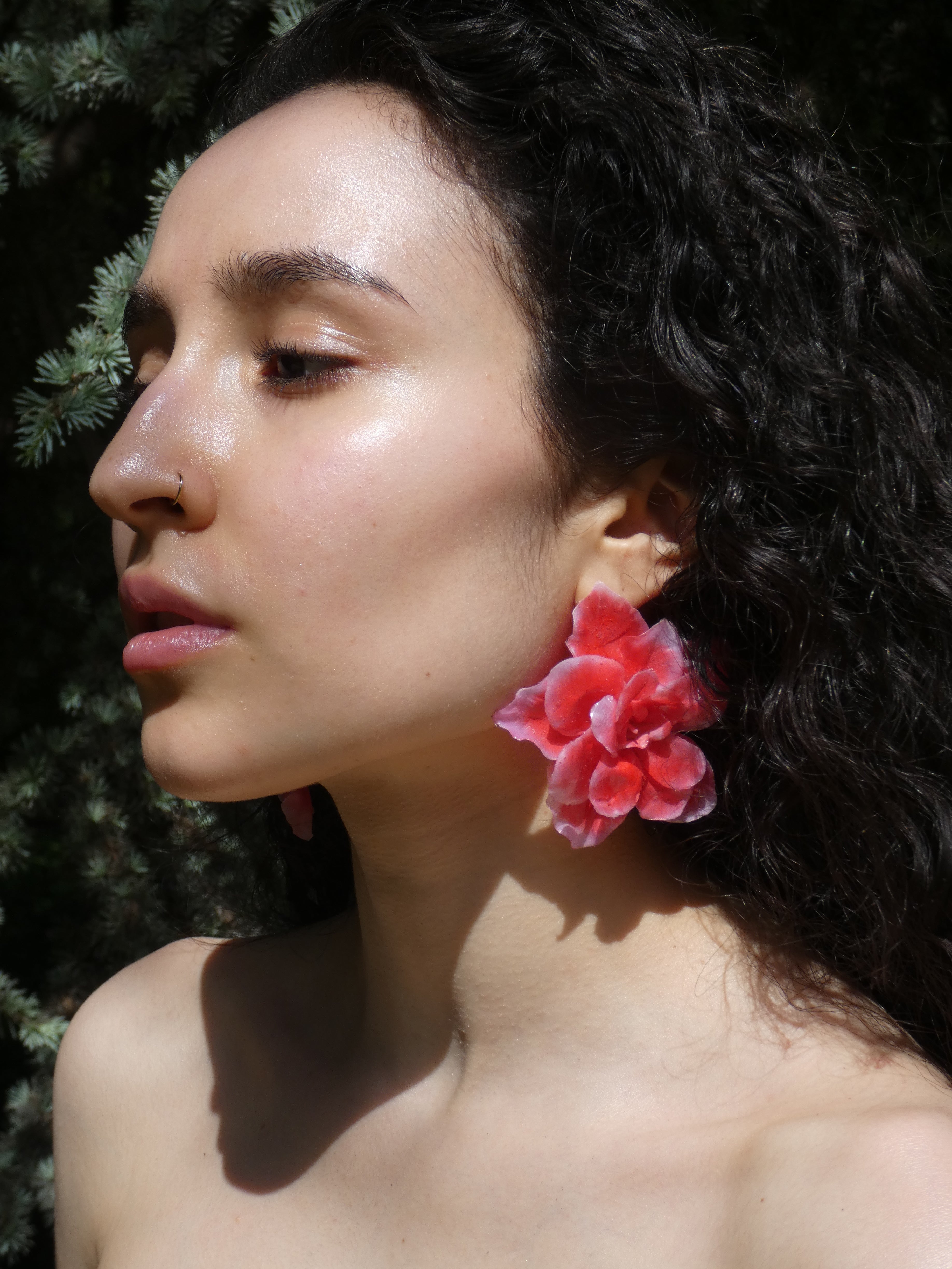 Grande boucle d’oreille florale rouge artisanale portée de côté
