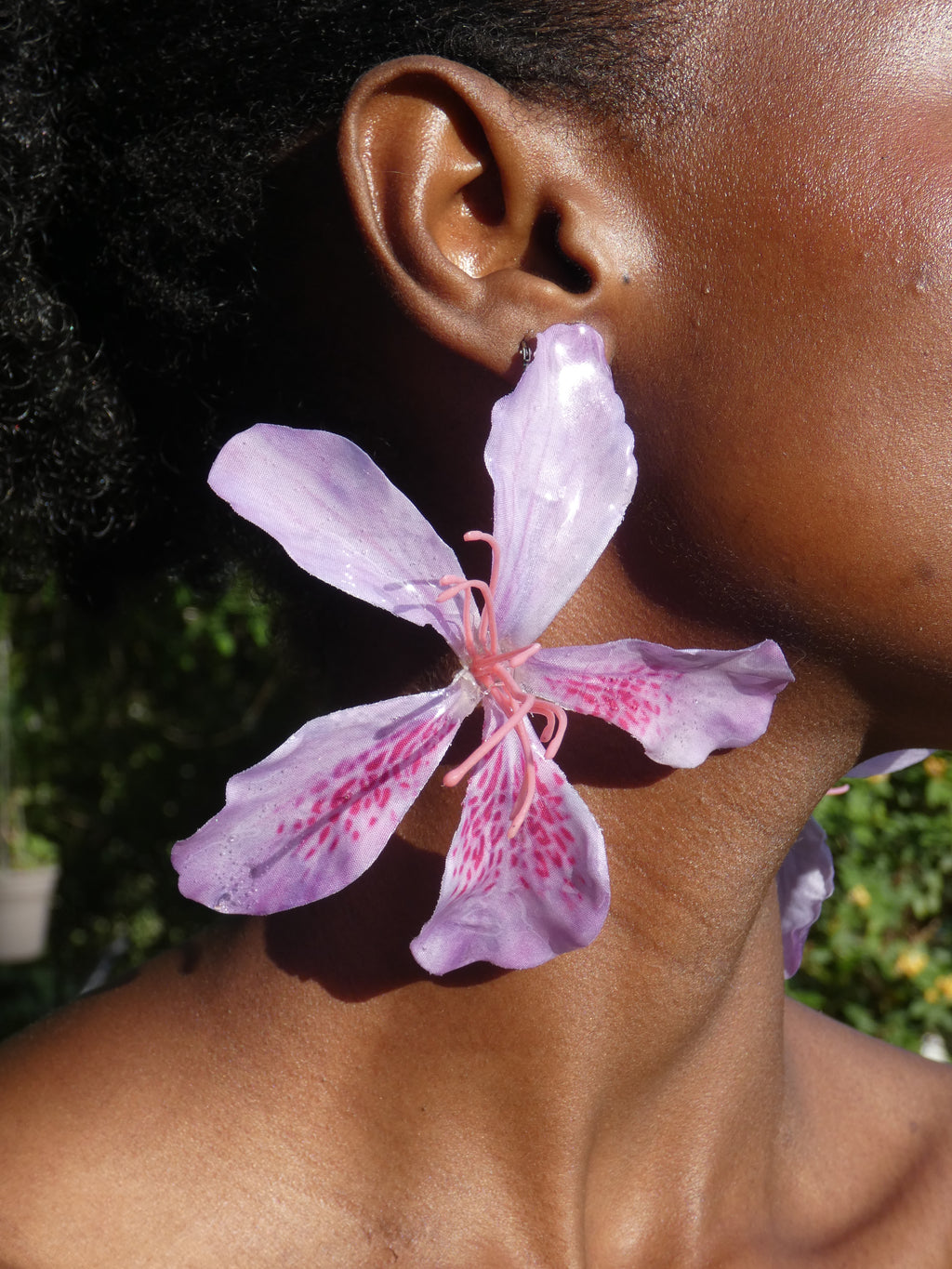 Grande boucle d’oreille fleur rose lilas artisanale portée par un modèle