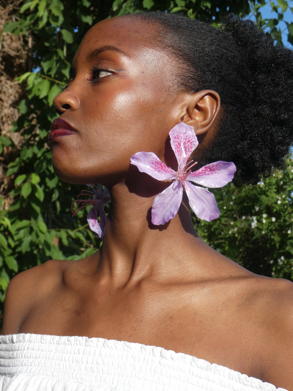 Boucle d’oreille florale rose pâle et lilas portée de profil