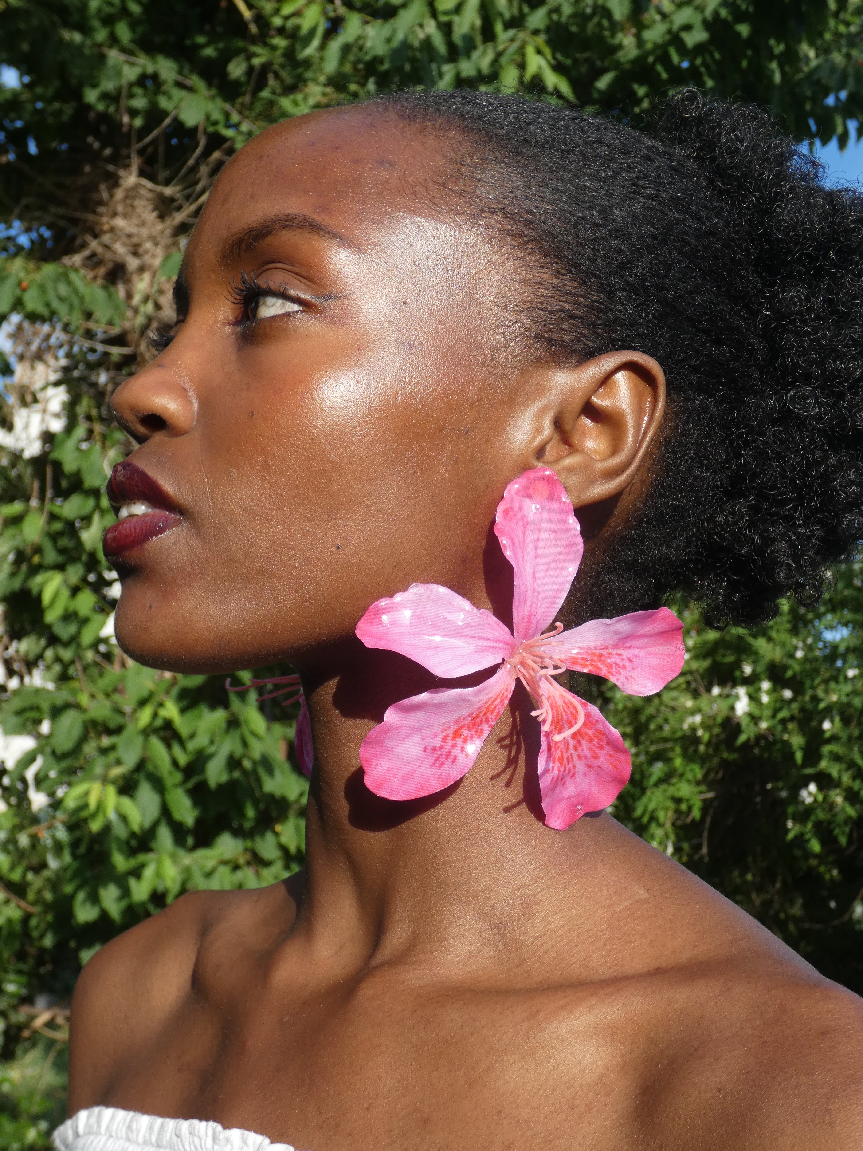 Boucle d’oreille florale rose vif inspirée des fleurs tropicales portée de profil