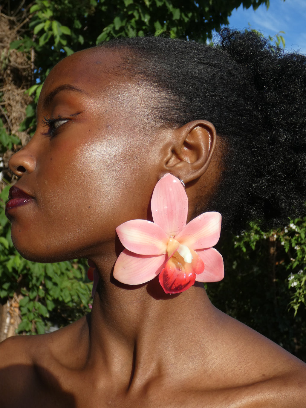 Boucle d’oreille fleur orchidée rose tendre portée en extérieur