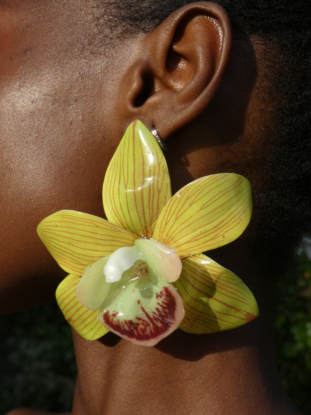 Grande boucle d'oreille orchidée verte artisanale artisanale portée par un modèle