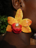 Grande boucle d'oreille orchidée jaune portée de profil