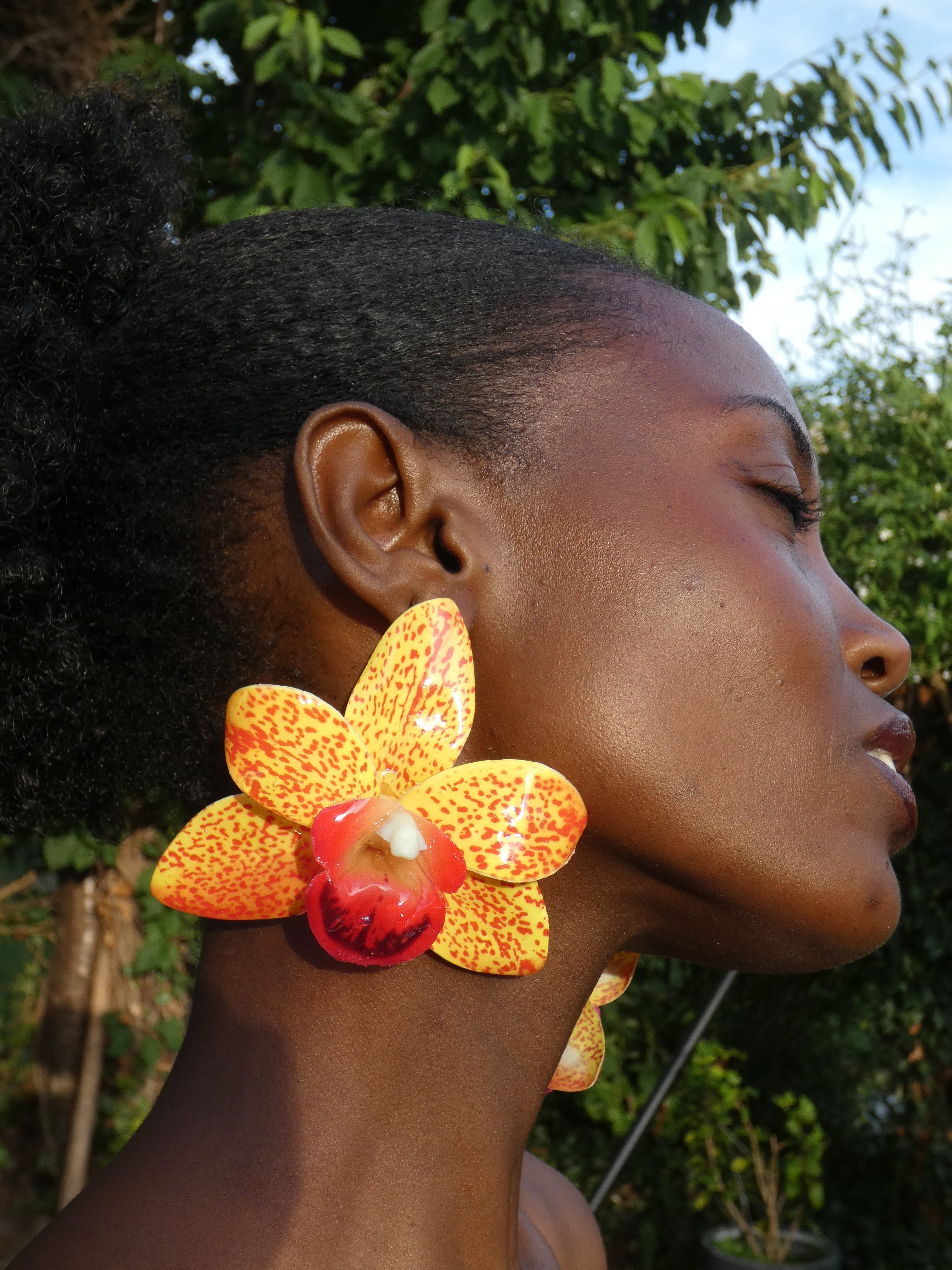 Boucle d'oreille fleur orchidée tropicale jaune portée de profil