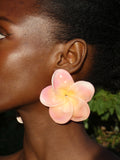Grande bouckle d'oreille fleur plumeria rose pastel artisanale porté par un modèle