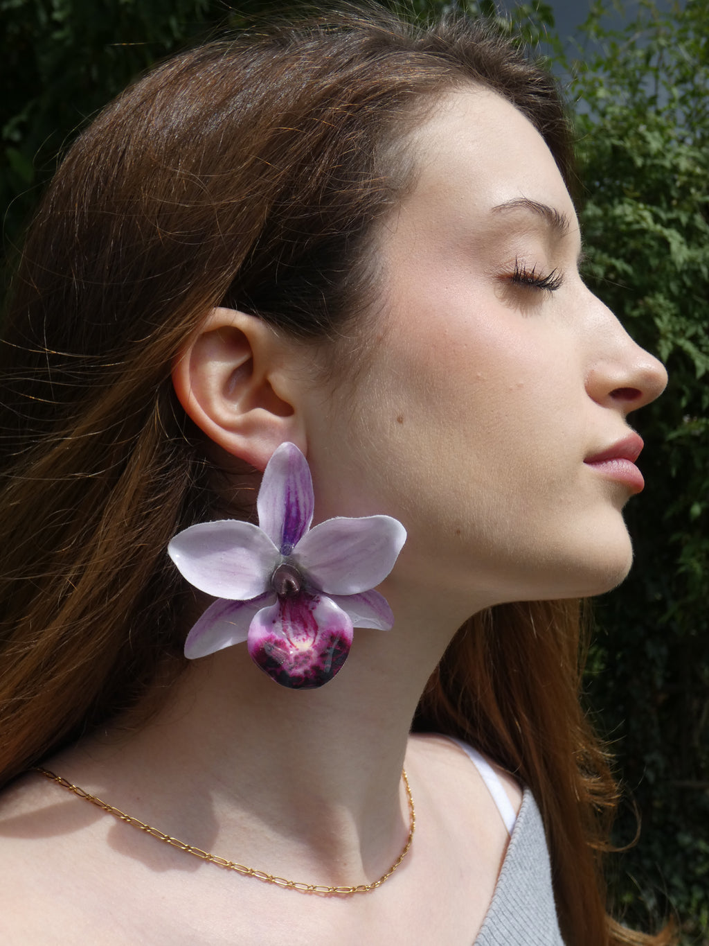 Grande boucle d'oreille fleur orchidée lilas, lavande et fuchsia portée en extérieur