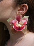 Grande boucle d'oreille fleur orchidée rose et verte artisanale porté par un modèle