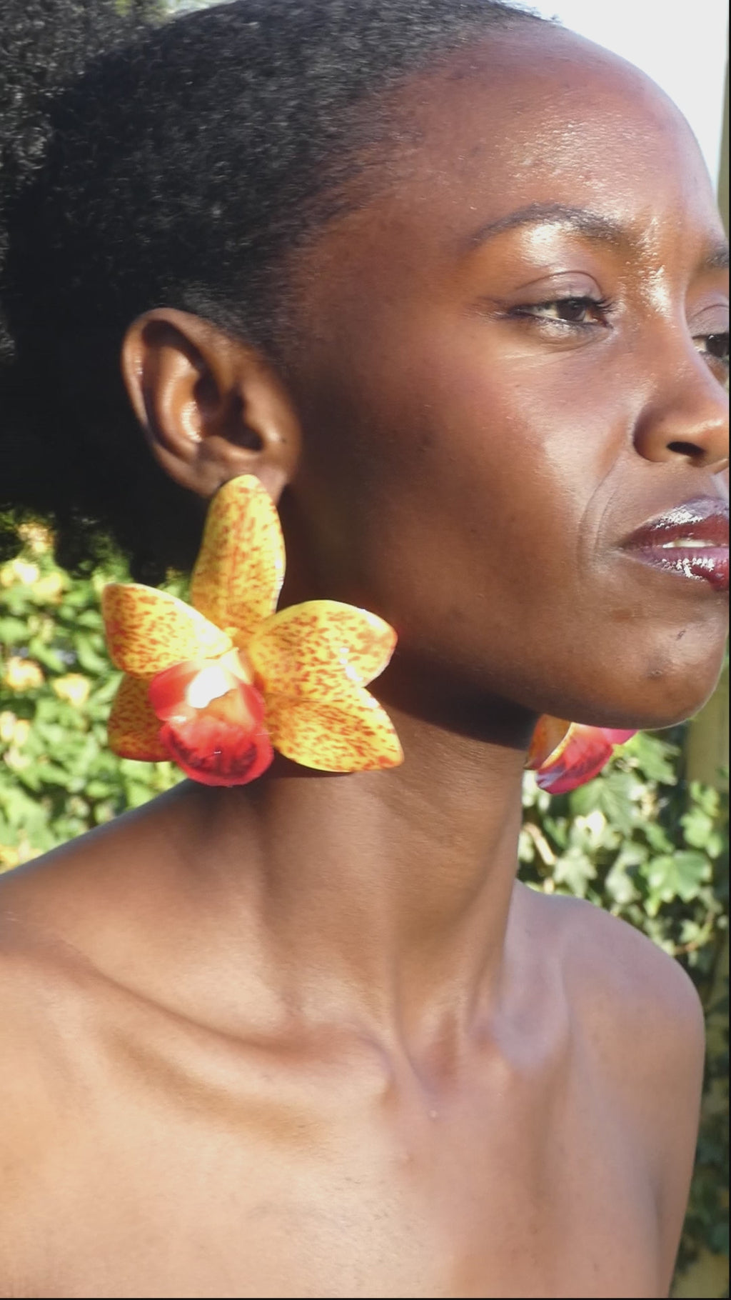 Vidéo montrant le mouvement et les détails d'une paire de boucle d'oreille orchidée jaune artisanale