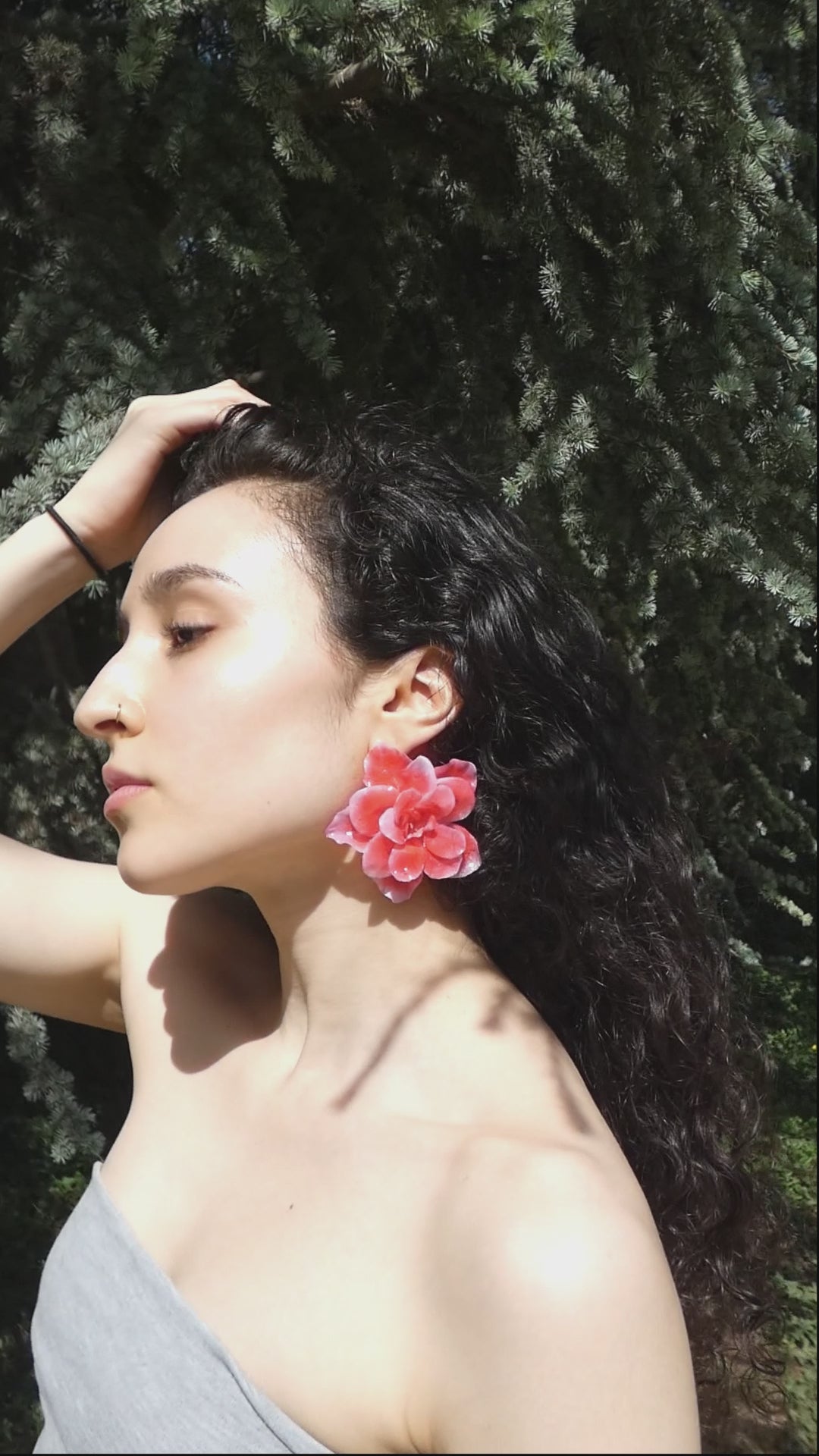 idéo montrant le mouvement, le volume et les détails d’une grande boucle d’oreille fleur rouge corail artisanale portée par un modèle