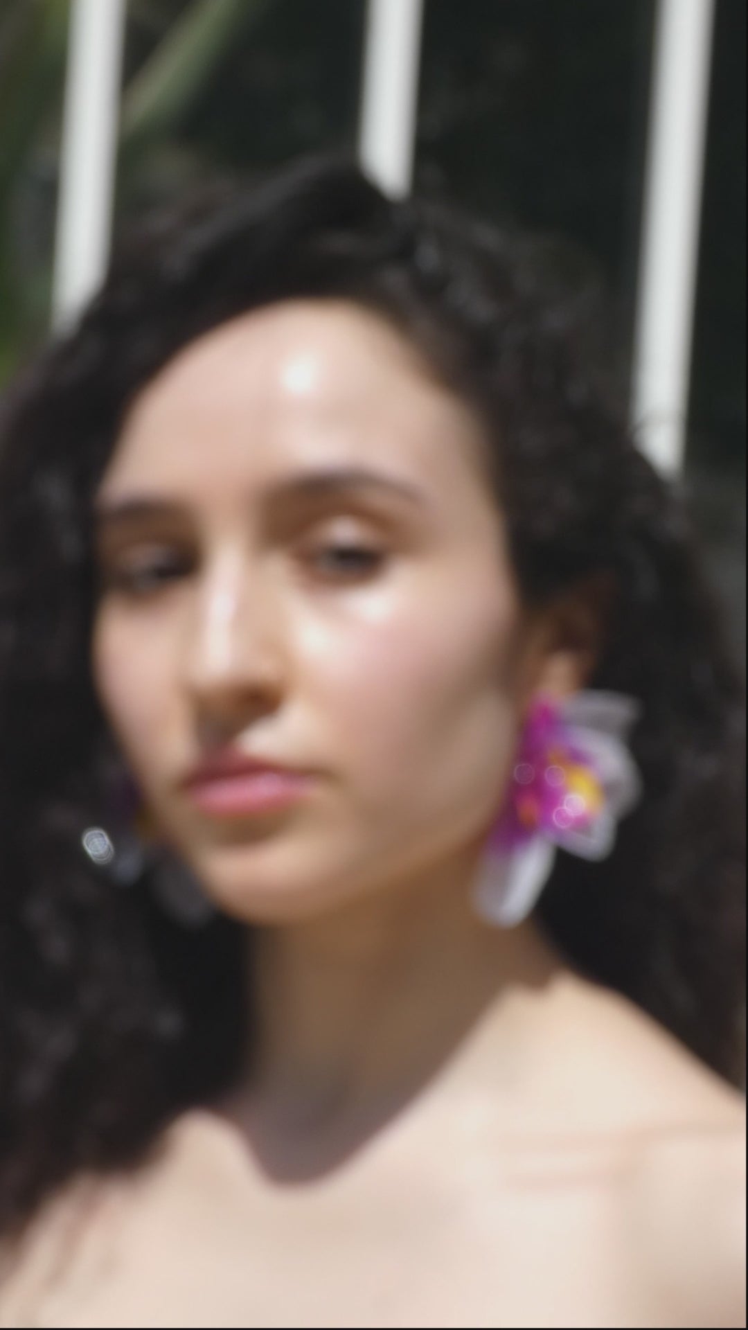 idéo montrant le mouvement et les détails d’une boucle d’oreille orchidée violette artisanale portée par un modèle