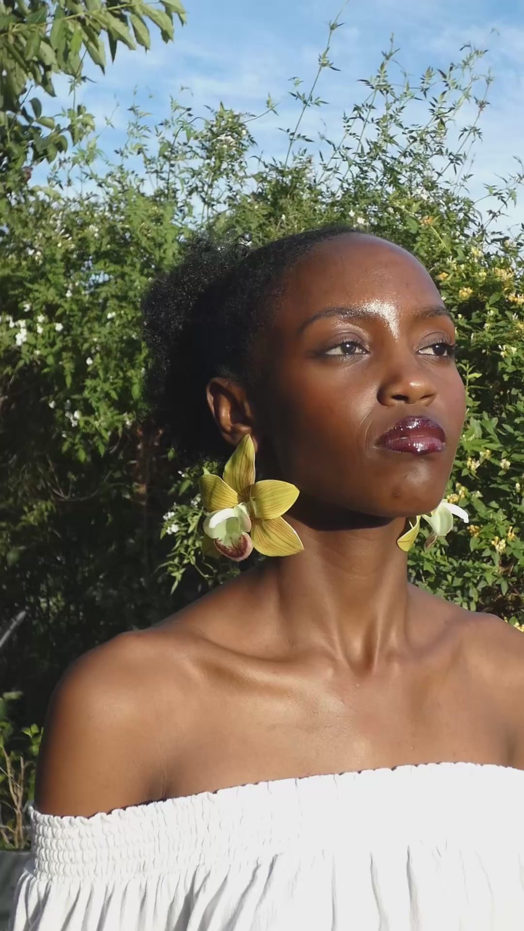 Vidéo montrant les détails et le mouvement d'une boucle d'oreille orchidée verte artisanale